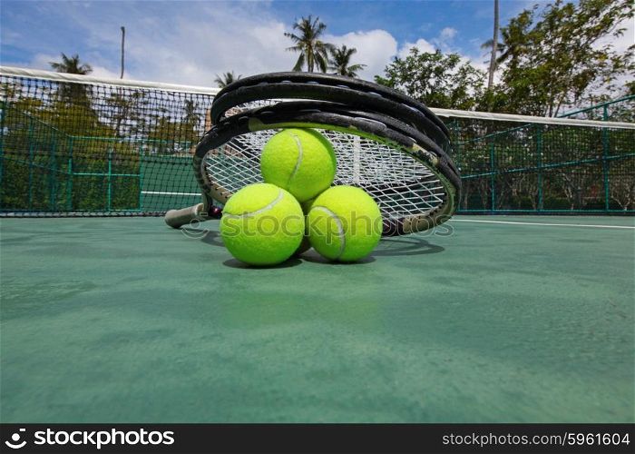 Tennis balls and racquets on court. Tennis balls and racquets on the court close-up