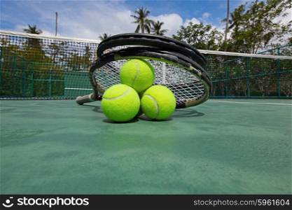 Tennis balls and racquets on court. Tennis balls and racquets on the court close-up