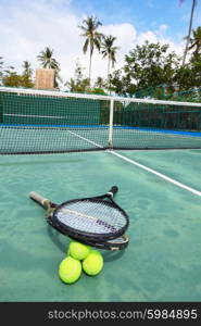 Tennis balls and racquets on court. Tennis balls and racquets on the court close-up