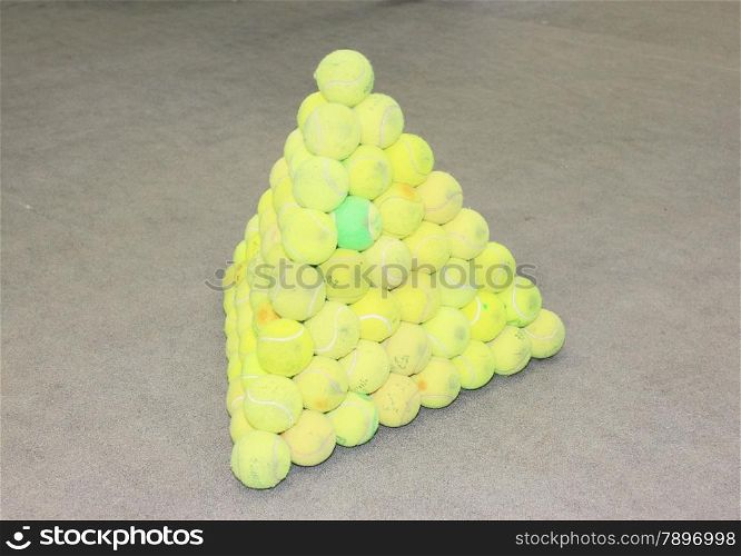 Tennis balls collected in the form a pyramid. Set of tennis balls.
