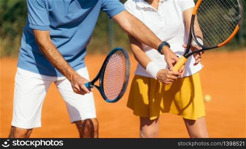 Tennis Instructor with Senior Woman on Clay Court. Woman having a Tennis Lesson.