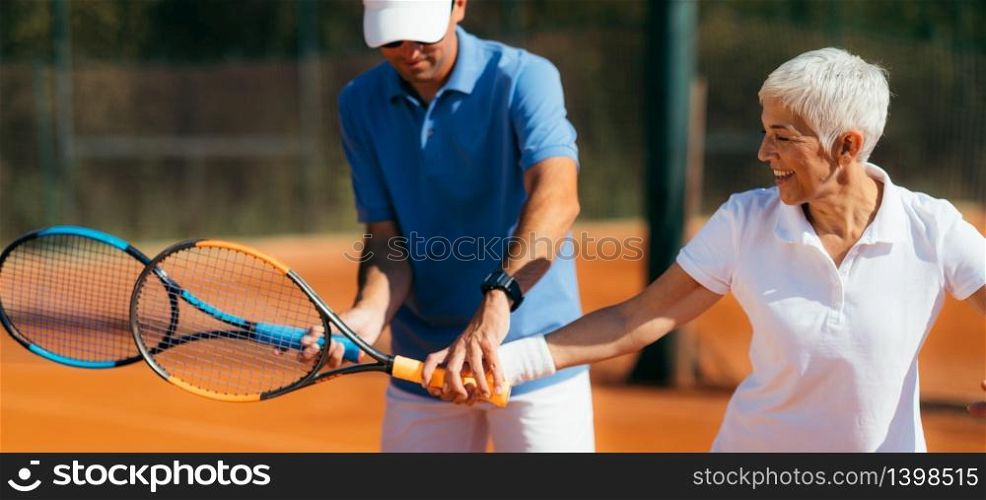 Tennis instructor with senior woman, tennis training lesson