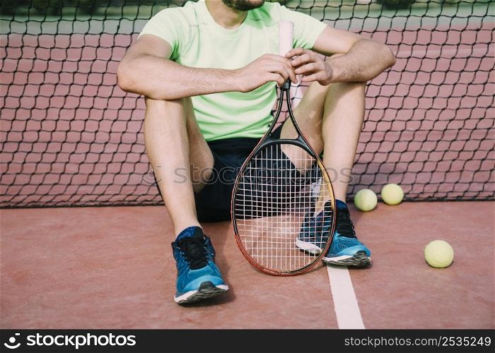 tennis layer leaning against net