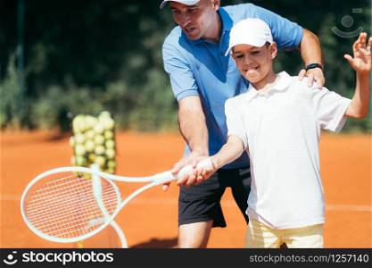 Tennis Lesson - Boy Training with Tennis Instructor on a Clay Court
