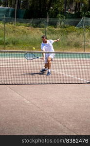 Tennis player performing a drop shot on court.