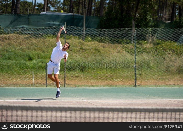 Tennis player performing a service on court.