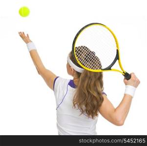 Tennis player serving ball. rear view