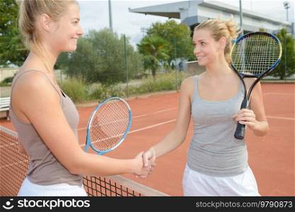 Tennis players shaking hands over net