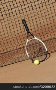 Tennis racket a tennis ball against a tennis net