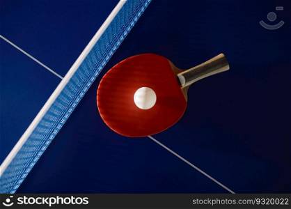 Tennis racket and ball on ping-pong table with net prepared for game completion. Professional sport and hobby concept. Tennis racket and ball on ping-pong table with net prepared for game