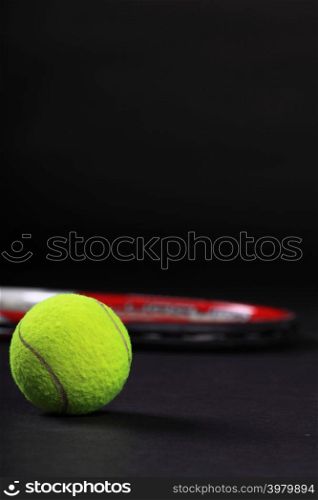 tennis racket and balls on black background studio shot