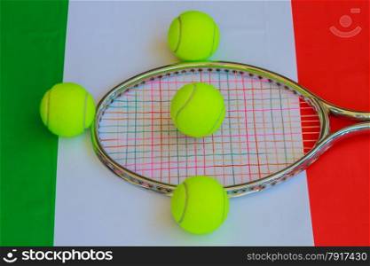 tennis racket in metal with colored ropes and yellow tennis balls with the italian flag in the background