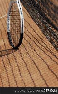 Tennis racket near a tennis net on a tennis court
