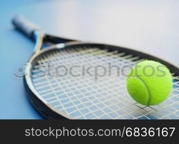 Tennis racket with ball on court