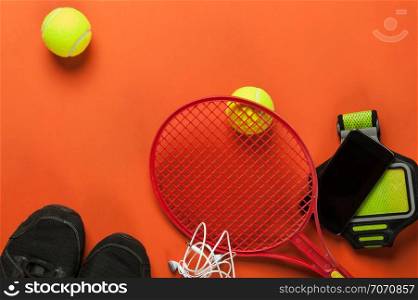 tennis set with tennis racket and smartphone on red background
