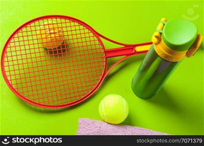 tennis set with thermos on green background
