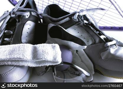 Tennis shoes, racquet, ball, glove and head band used to play racquetball.