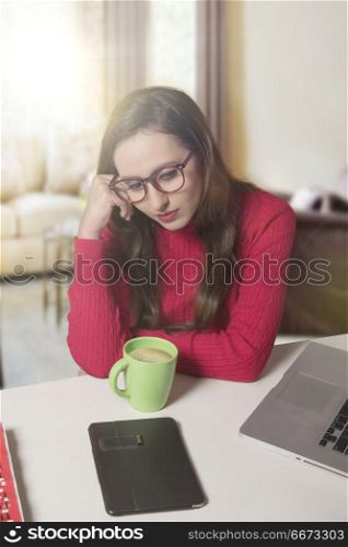 Tensed businesswoman at laptop with head in hands
