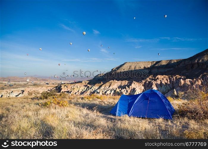 Tent and many balloons above Cappadocia, Turkey