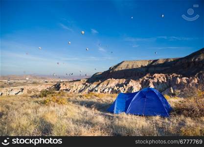 Tent and many balloons above Cappadocia, Turkey