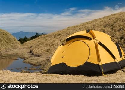 Tent and small lake in high mountain.