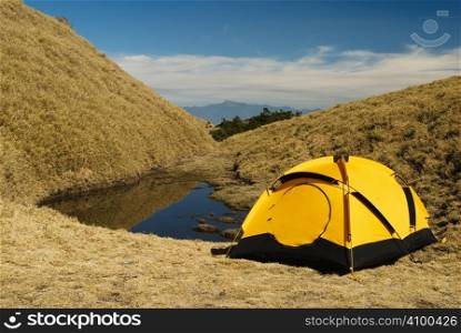 Tent and small lake in high mountain.