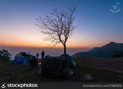 Tent area on sunset or sunrise on hill / Landscape camping tents in the wild mountain with the tourist traveler with twilight sky