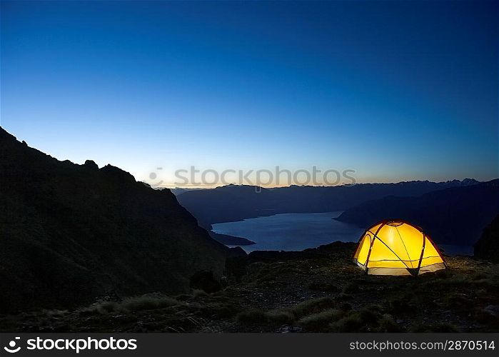 Tent by lakeshore at dusk