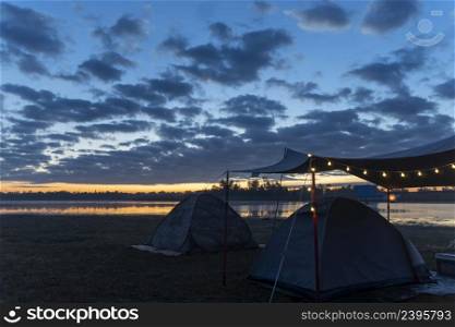 Tent camping in the morning sunrise at the lakeside