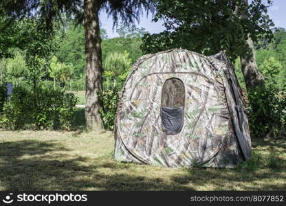 Tent on campsite between the trees. Sun light