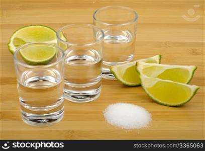 tequila, lime and salt on a wooden background
