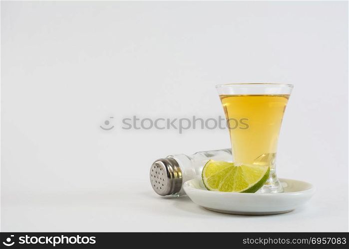 Tequila shot with lime and salt on white background. Gold Mexican tequila. Tequila. Tequila shot with lime and salt on white background