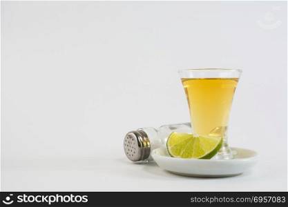 Tequila shot with lime and salt on white background. Gold Mexican tequila. Tequila. Tequila shot with lime and salt on white background