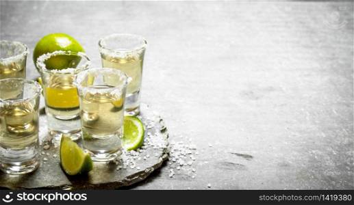 Tequila with lime and salt. On the stone table.. Tequila with lime and salt.