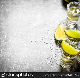 Tequila with lime and salt. On the stone table.. Tequila with lime and salt.