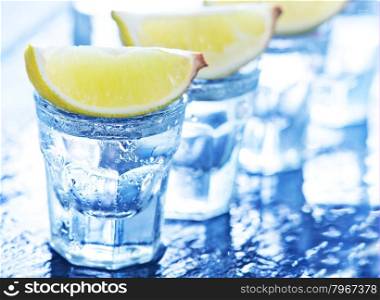 tequilla with limes on the black table