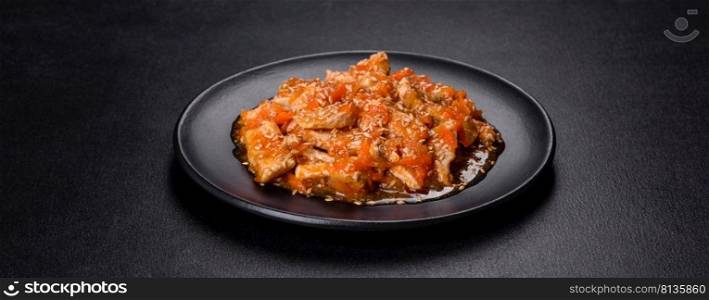 Teriyaki chicken with sauce, sesame, herbs and spices on a dark concrete background. Asian cuisine. Teriyaki chicken with sauce, sesame, herbs and spices on a dark background