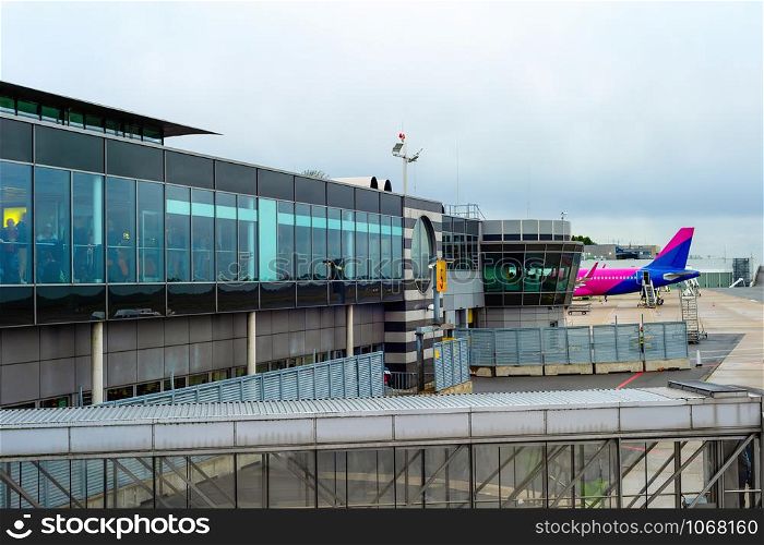 Terminal glass facade, airplane at runway by Dortmund international airport, cloudy skyline, Dortmund, Germany