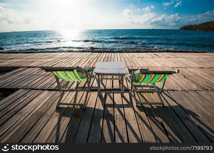 Terrace view of sea waves and coast landscape seascape with bench chair beach on wooden bridge balcony Tropical island with ocean blue sky background in Thailand summer beach vacation and table set
