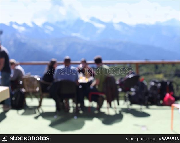 terrace with people and mountain views. Blur background.