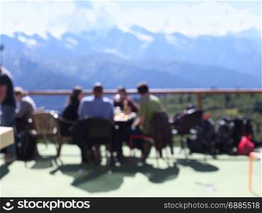 terrace with people and mountain views. Blur background.