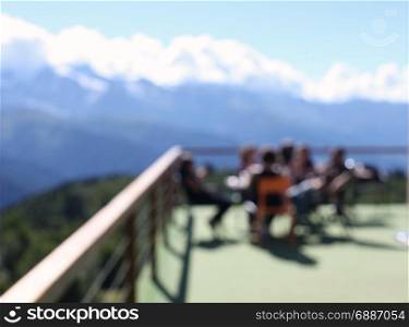 Terrace with people and mountain views. Blur background.