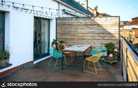 Terrace with table and chairs and garland of lights. Terrace with table and chairs