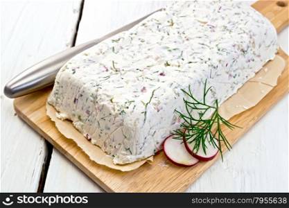 Terrine of curd and radish with dill, chives, knife on paper and board on a light wooden planks