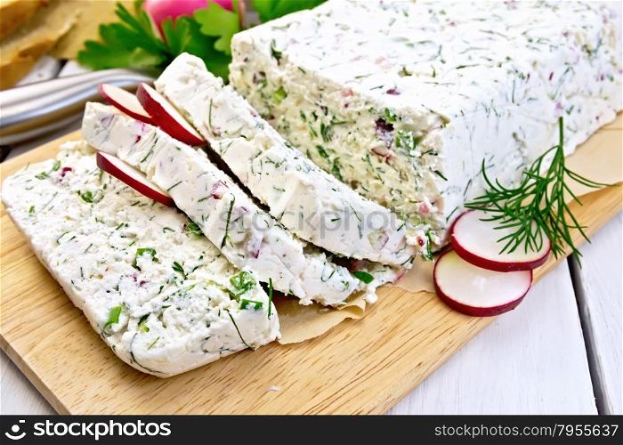Terrine of curd and radish with dill, green onions on a paper and a board, knife, bread, parsley on a light wooden planks