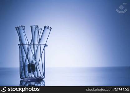 Test tubes in glass beaker with blue tint.