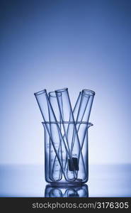 Test tubes in glass beaker with blue tint.