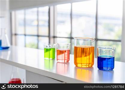 test tubes with lab glassware on the table in laboratory background, research and Scientific concept