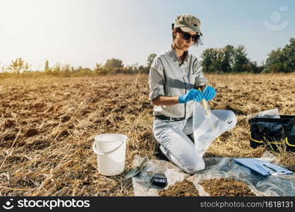 Testing Soil. Agronomist opening soil s&le bag in the field. Environmental protection, organic soil certification, Soil Fertility Analysis