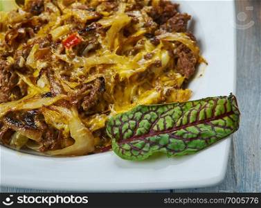 Tex Mex Cabbage Beef Skillet opped with Spicy Mexican Cheese Blend, Tex-Mex  cuisine, Traditional assorted dishes, Top view.